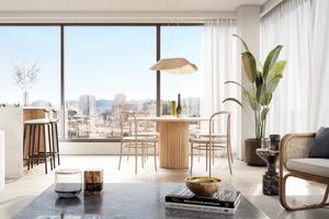 A photograph of a living room with large windows overlooking San Francisco on a clear day.