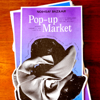 An 11x17 poster featuring a purple to blue gradient and a black and white photograph of a crumpled piece of clothing. Text says "Pop-up Market".